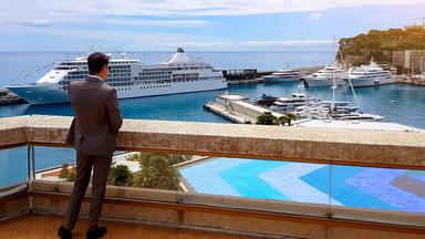 Ein Geschäftsmann telefoniert und genießt den Blick auf eine neue Yacht im Privathafen
