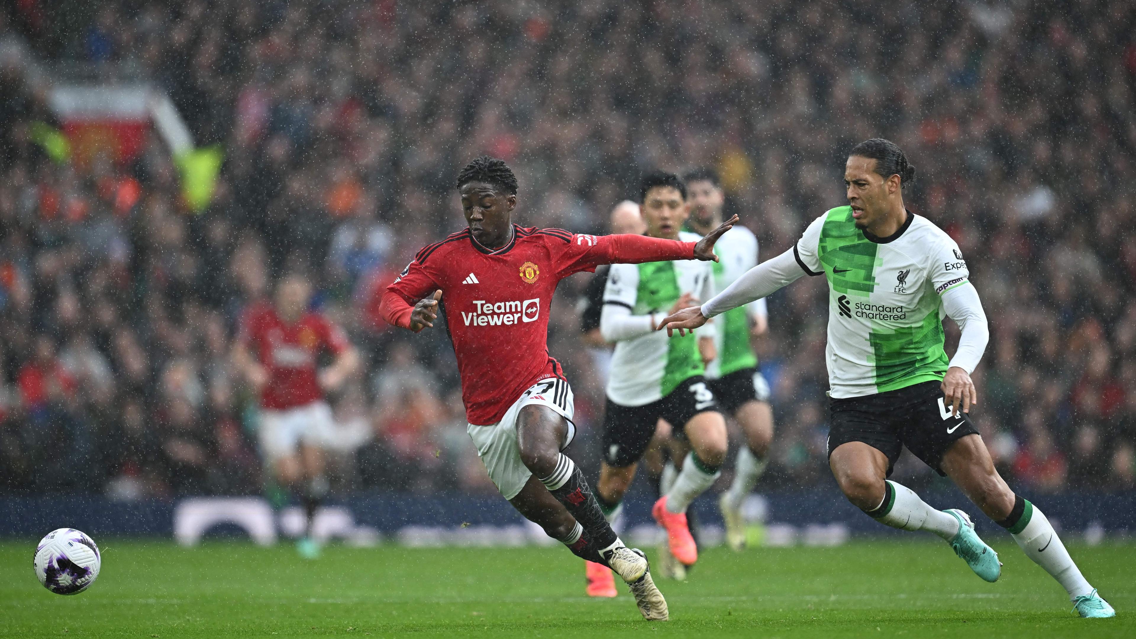 Manchester United's Kobbie Mainoo (l) im Zweikampf mit Virgil van Dijk (r).
