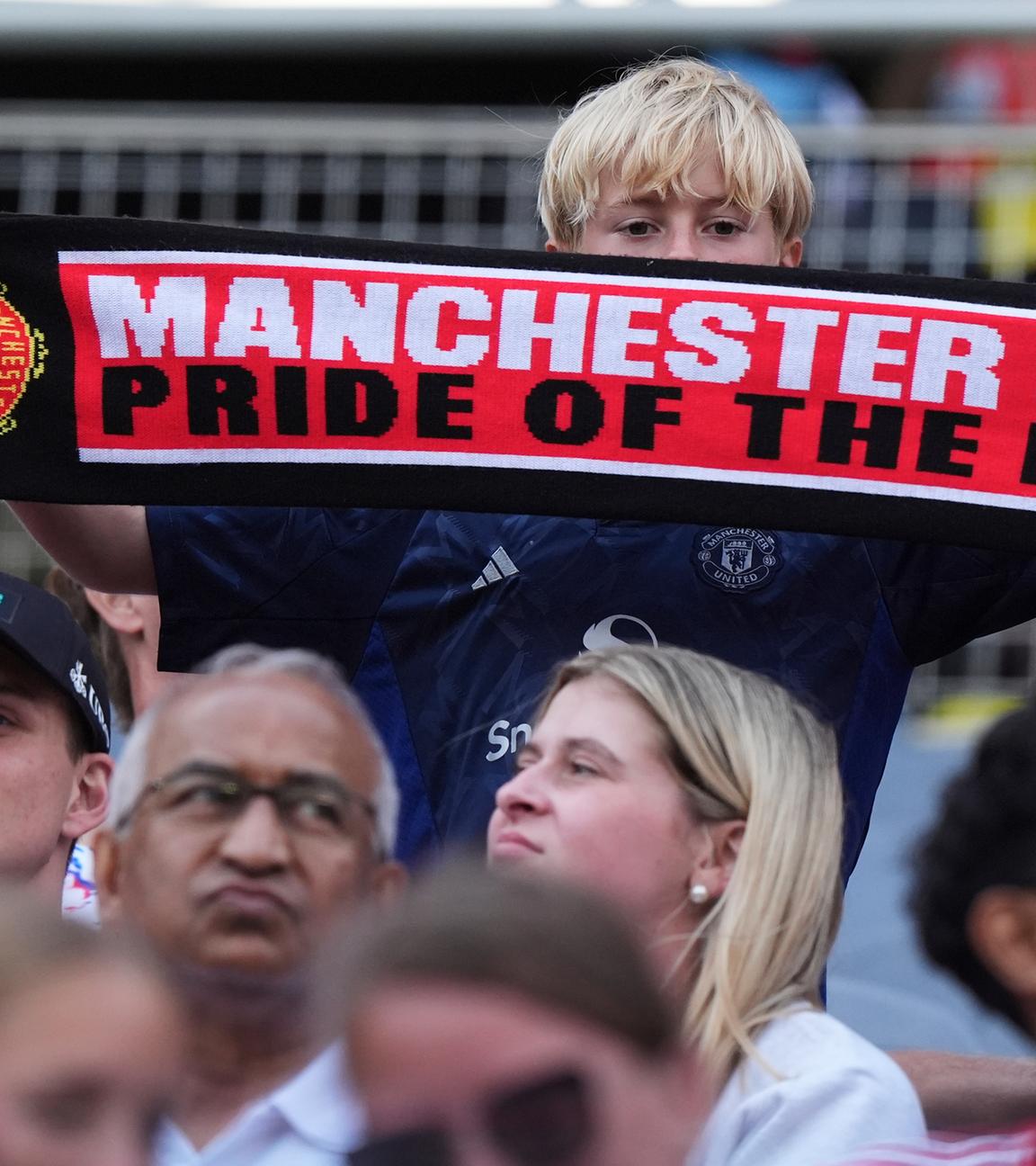 Ein Manchester United Fan hält einen Schal mit der Aufschrift: "Manchester United, Pride of the North" hoch.