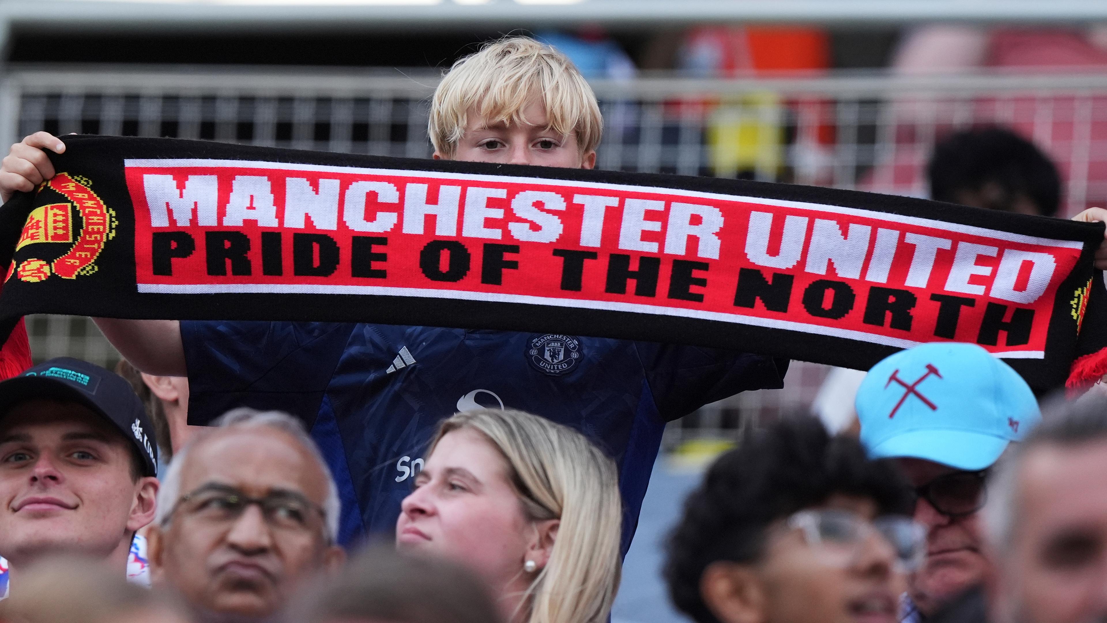 Ein Manchester United Fan hält einen Schal mit der Aufschrift: "Manchester United, Pride of the North" hoch.