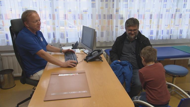 Vater und Sohn beim Kinderarzt