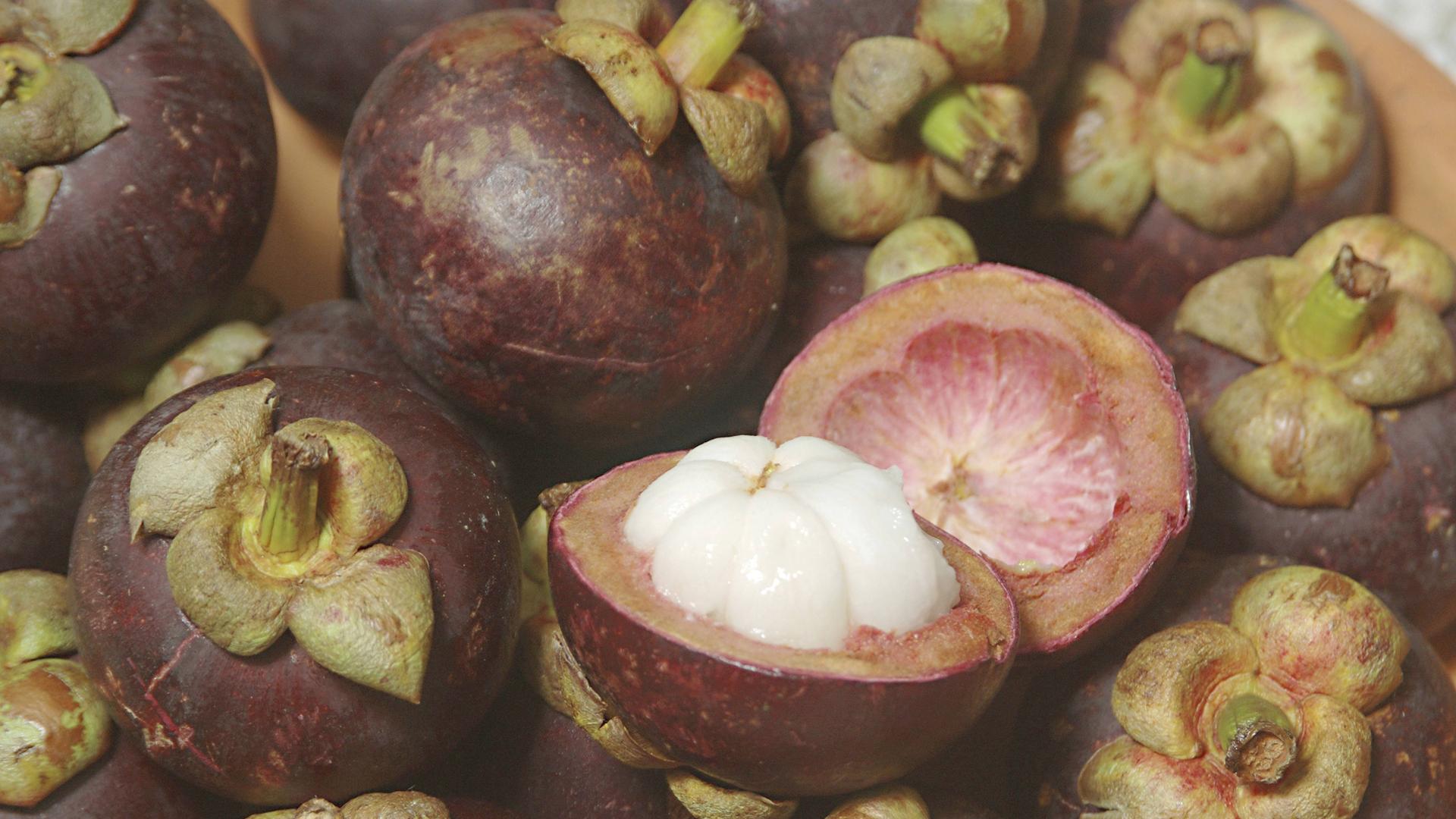 Viele Mangostan Früchte liegen in einer Schale.