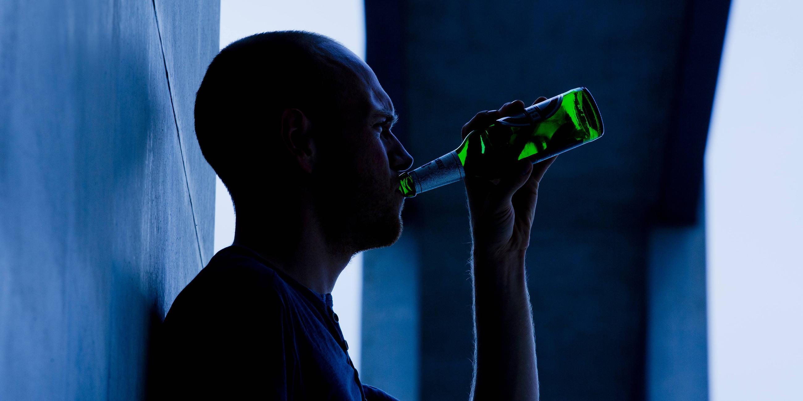 Mann trinkt aus einer Bierflasche