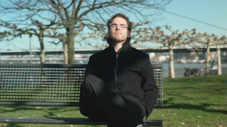 Mann mit geschlossenen Augen auf einer Bank