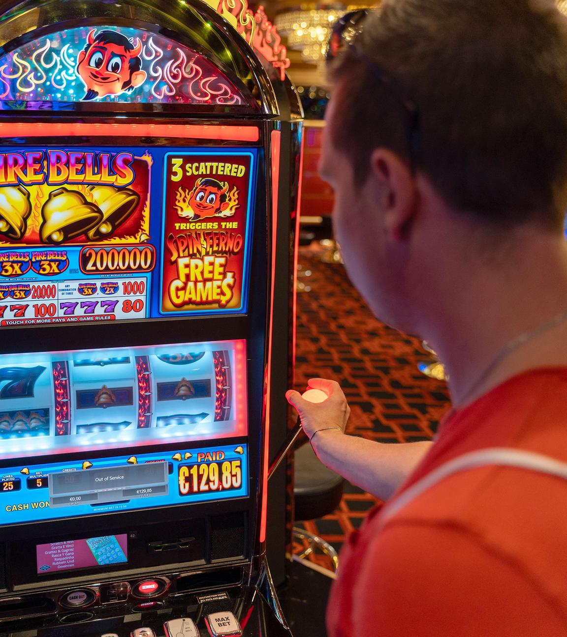 Ein junger Mann spielt an einem Spielautomaten in einem Casino
