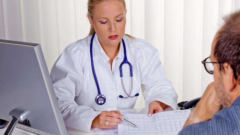 Mann im Patientengespräch mit einer jungen Ärztin