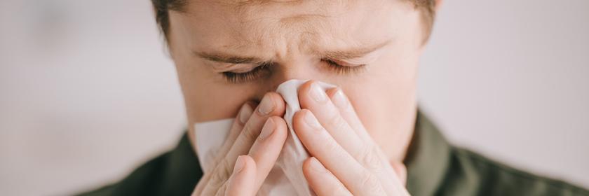 Mann putzt sich die Nase