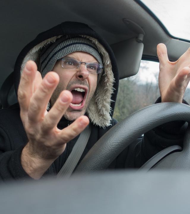 Ein Mann schreit im Auto 