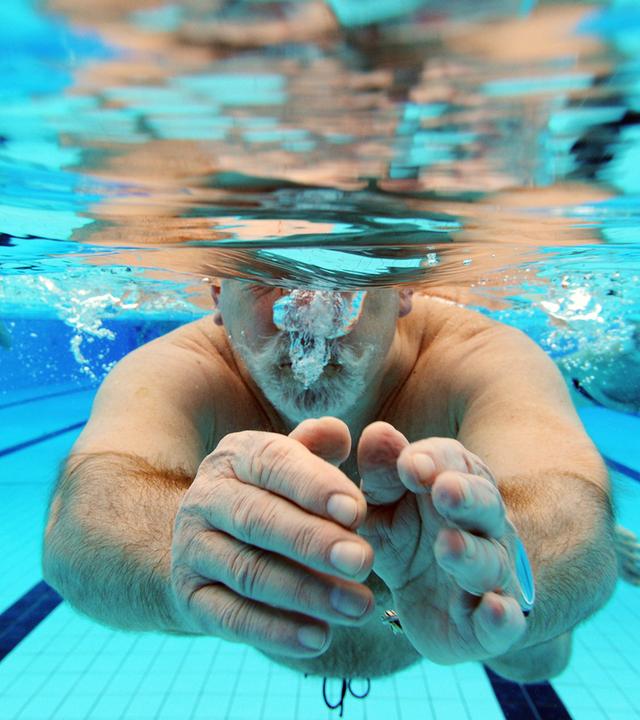 Unterwasseraufnahme von einem Mann, der auf die Kamera zuschwimmt