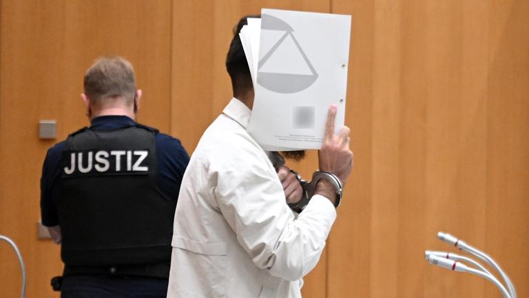 Täter hält sich Ordner vors Gesicht