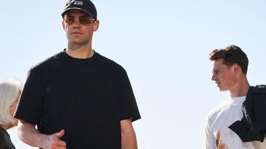 Manuel Neuer (links) und Jonas Urbig, beide Torhüter der Fußball-Nationalmannschaft, gehen am frühen Morgen auf der Promenade am Oak Street Beach am Lake Michigan entlang