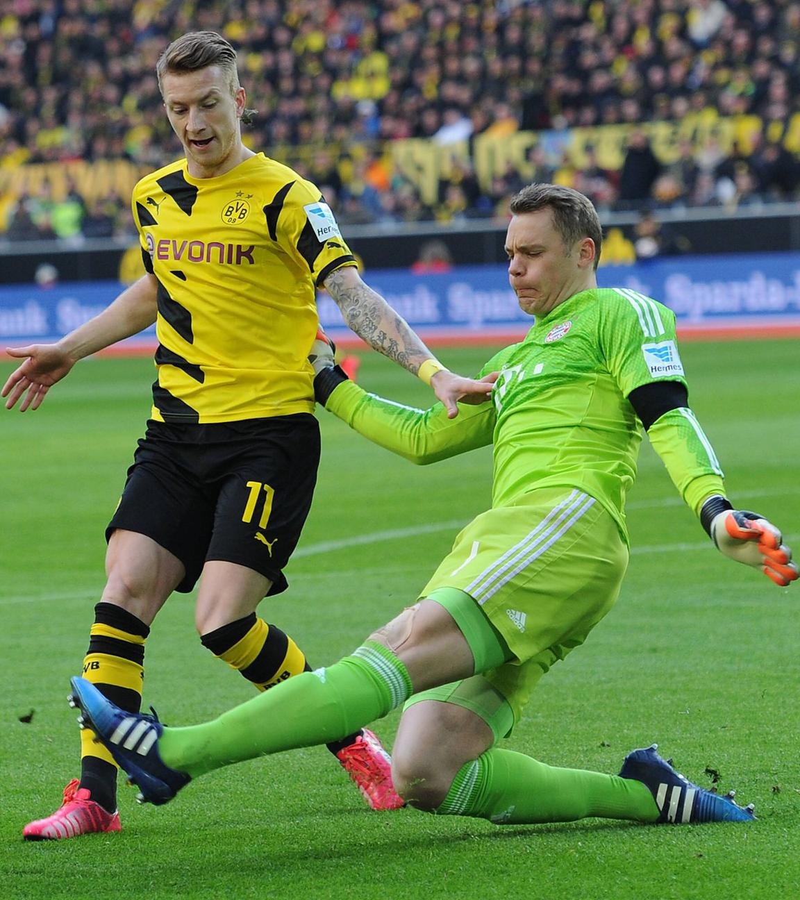 Manuel Nuer grätscht Marco Reus (l.)