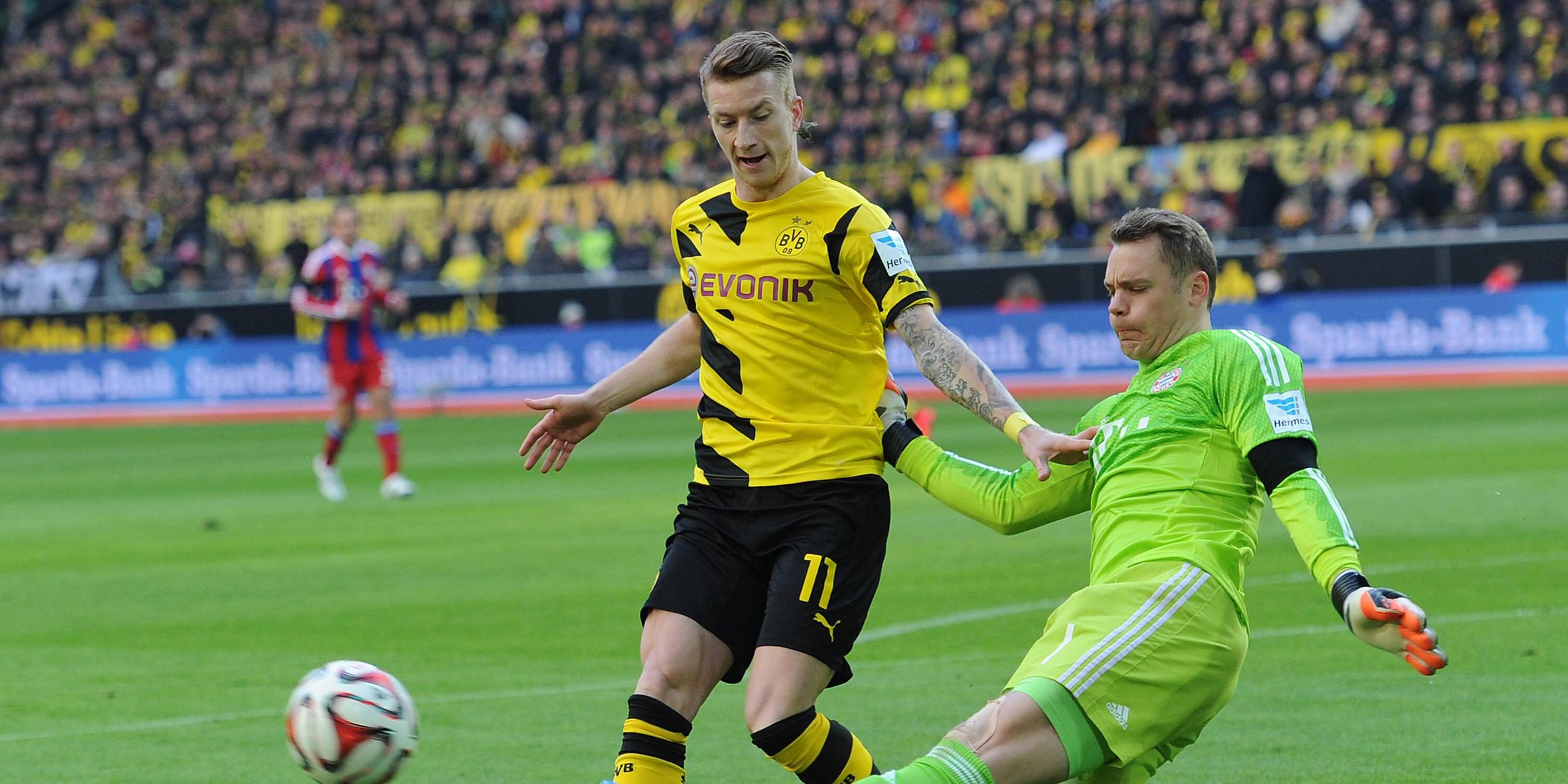 Manuel Nuer grätscht Marco Reus (l.)