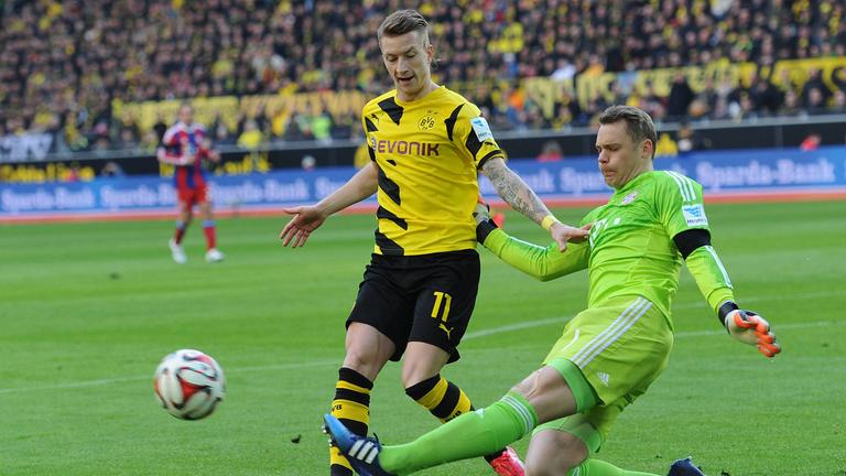 Manuel Nuer grätscht Marco Reus (l.)