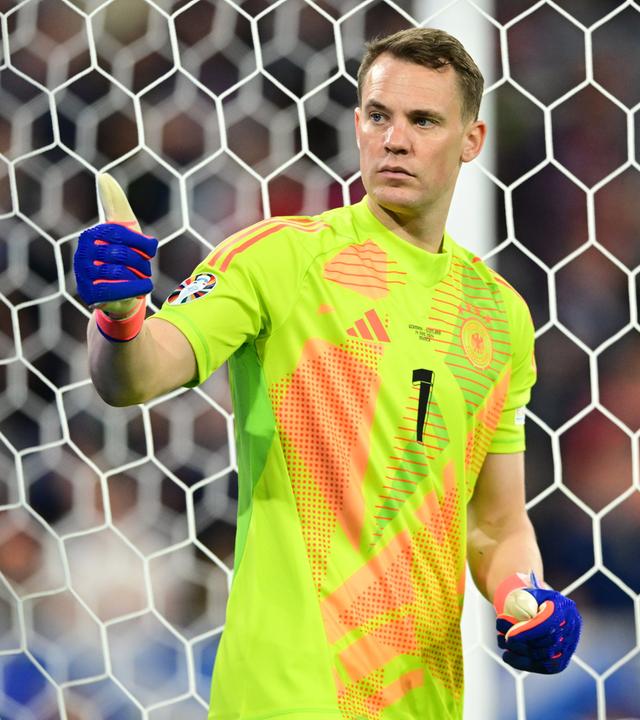Manuel Neuer steht im Tor und zeigt mit dem Daumen nach oben. 