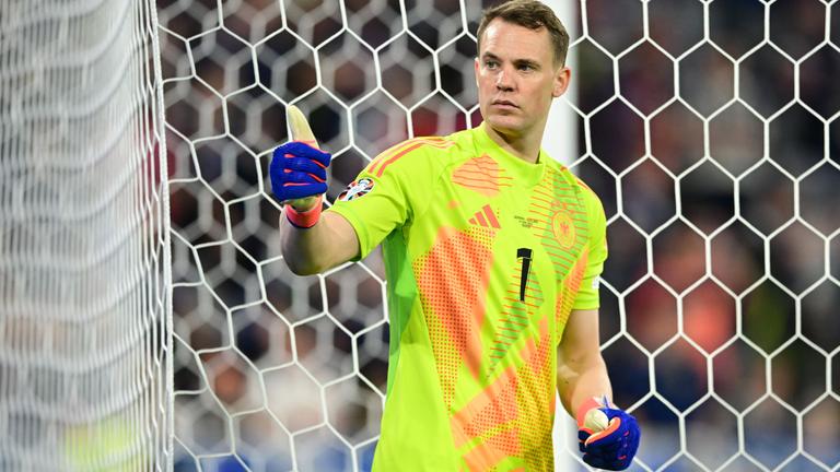 Manuel Neuer steht im Tor und zeigt mit dem Daumen nach oben. 
