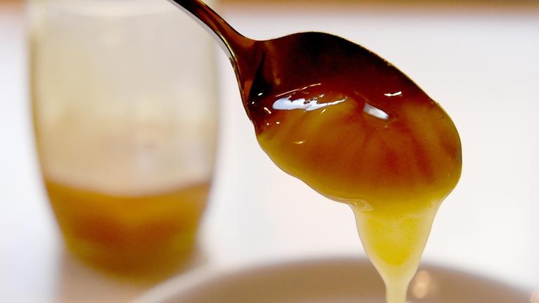 Zu sehen ist ein mit Manuka-Honig gefüllter Löffel.