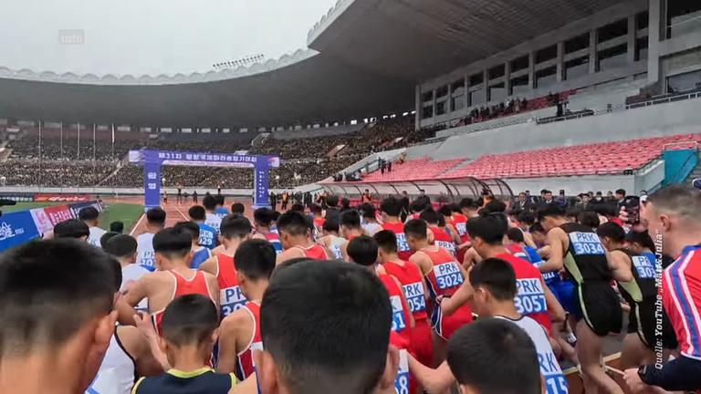 Stadion in Pjöngjang in Nordkorea, Blick auf den Rücken vieler Läufer