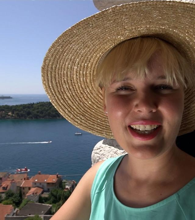 Marina Wenk mit Sonnenhut in Istrien, im Hintergrund sieht man das Meer.