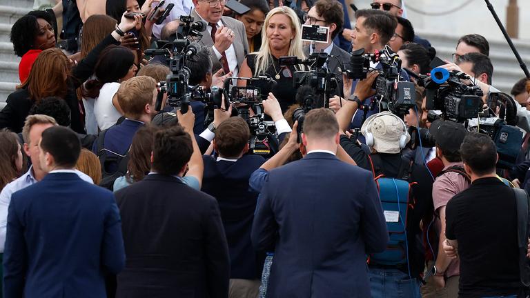 Die republikanische Abgeordnete Majorie Taylor Greene steht von Reportern umzingelt auf den Stufen des US-Kapitols. 