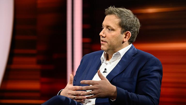 Markus Lanz sitzt auf einem Stuhl