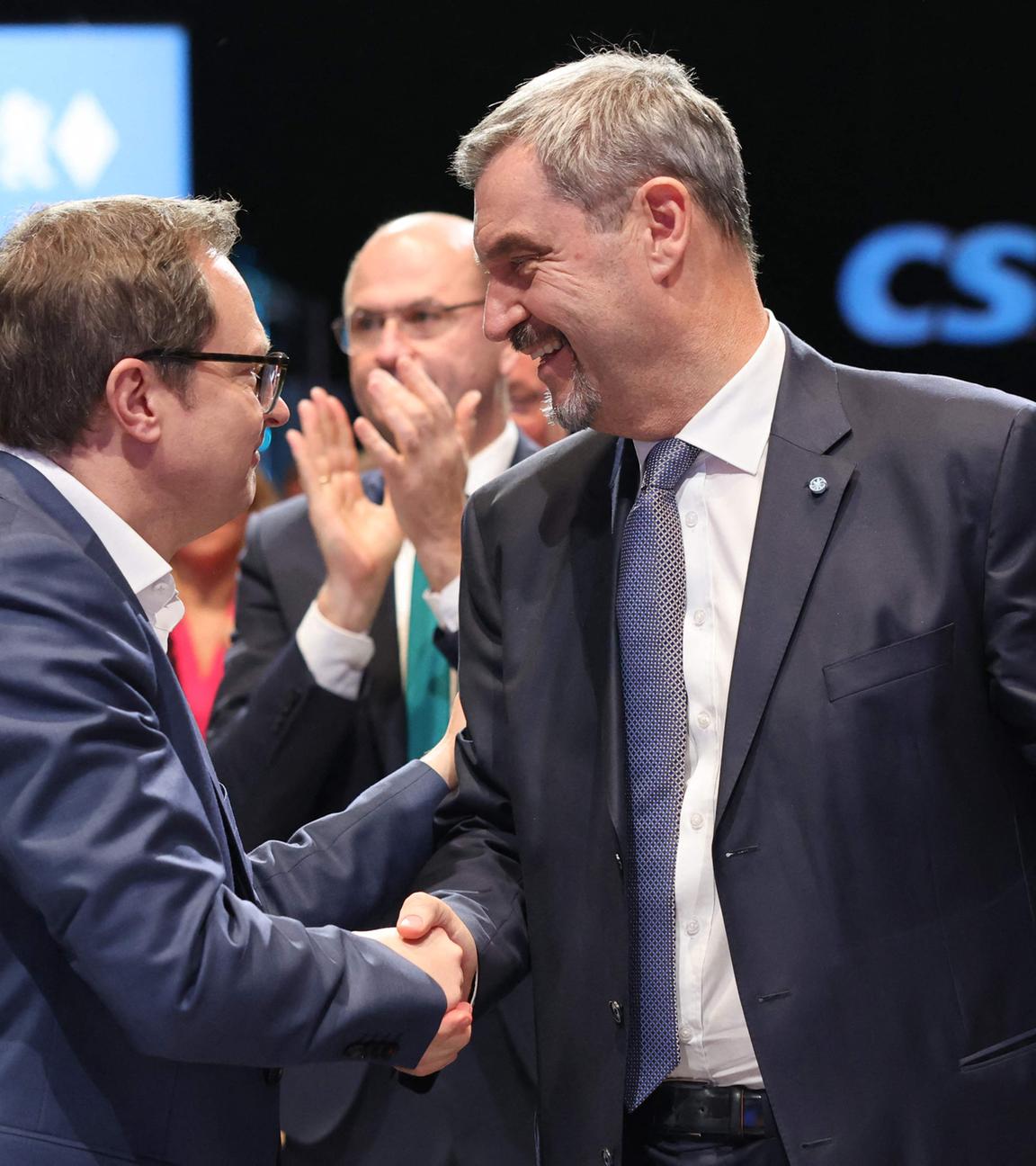 Der Generalsekretär der bayerischen konservativen Christlich-Sozialen Union (CSU), Martin Huber, gratuliert Bayerns Ministerpräsident und CSU-Vorsitzender Markus Söder nach dessen Wiederwahl während eines Parteitags der Christlich-Sozialen Union (CSU) am 12.12.2025 in München, Süddeutschland.