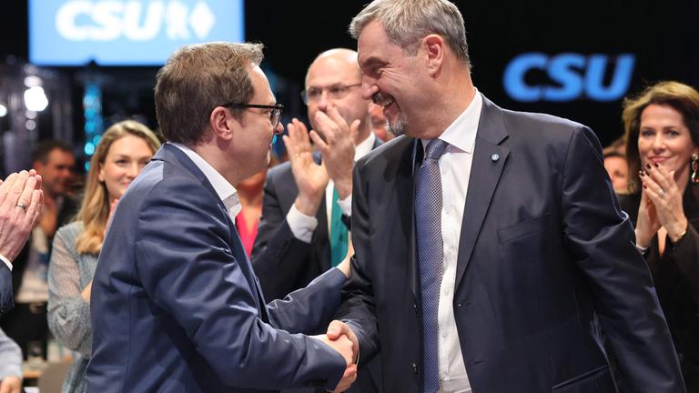 Der Generalsekretär der bayerischen konservativen Christlich-Sozialen Union (CSU), Martin Huber, gratuliert Bayerns Ministerpräsident und CSU-Vorsitzender Markus Söder nach dessen Wiederwahl während eines Parteitags der Christlich-Sozialen Union (CSU) am 12.12.2025 in München, Süddeutschland.