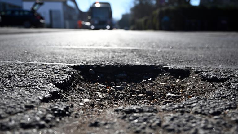 Ein Schlagloch auf einer deutschen Straße.