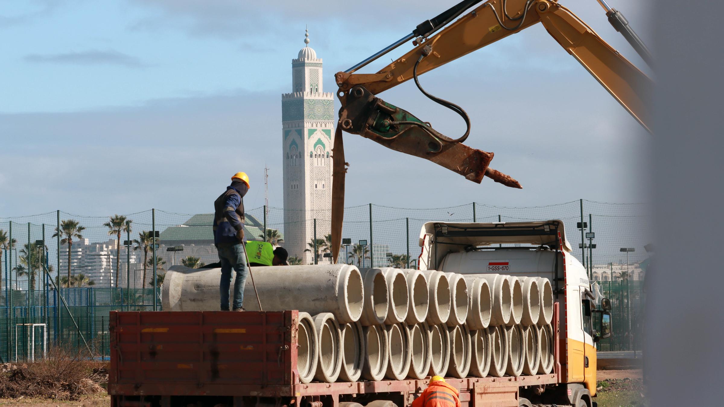 Lastwagen mit Baumaterialieren und einem Bauarbeiter.