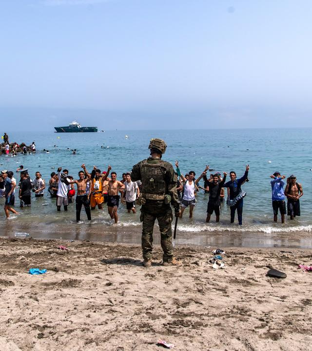 Soldaten der spanischen Armee versperren Menschen, die von Marokko in die spanische Exklave Ceuta gelangen wollen, den Zugang zum Strand.