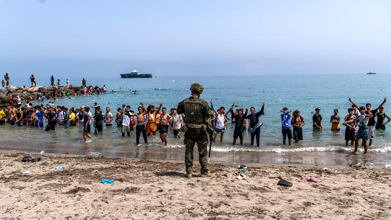 Soldaten der spanischen Armee versperren Menschen, die von Marokko in die spanische Exklave Ceuta gelangen wollen, den Zugang zum Strand.