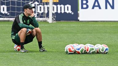 Mexikos neuer Trainer sitzt auf einem Ball beim Training der Nationalmannschft.