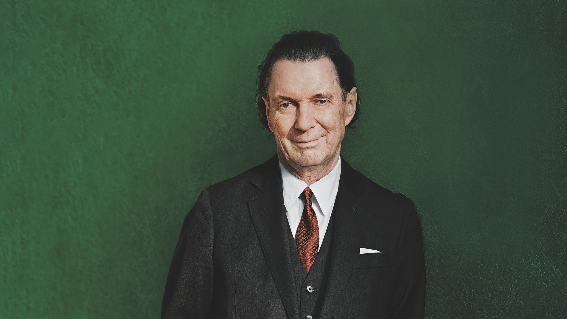 Autor Martin Suter vor grünem Hintergrund