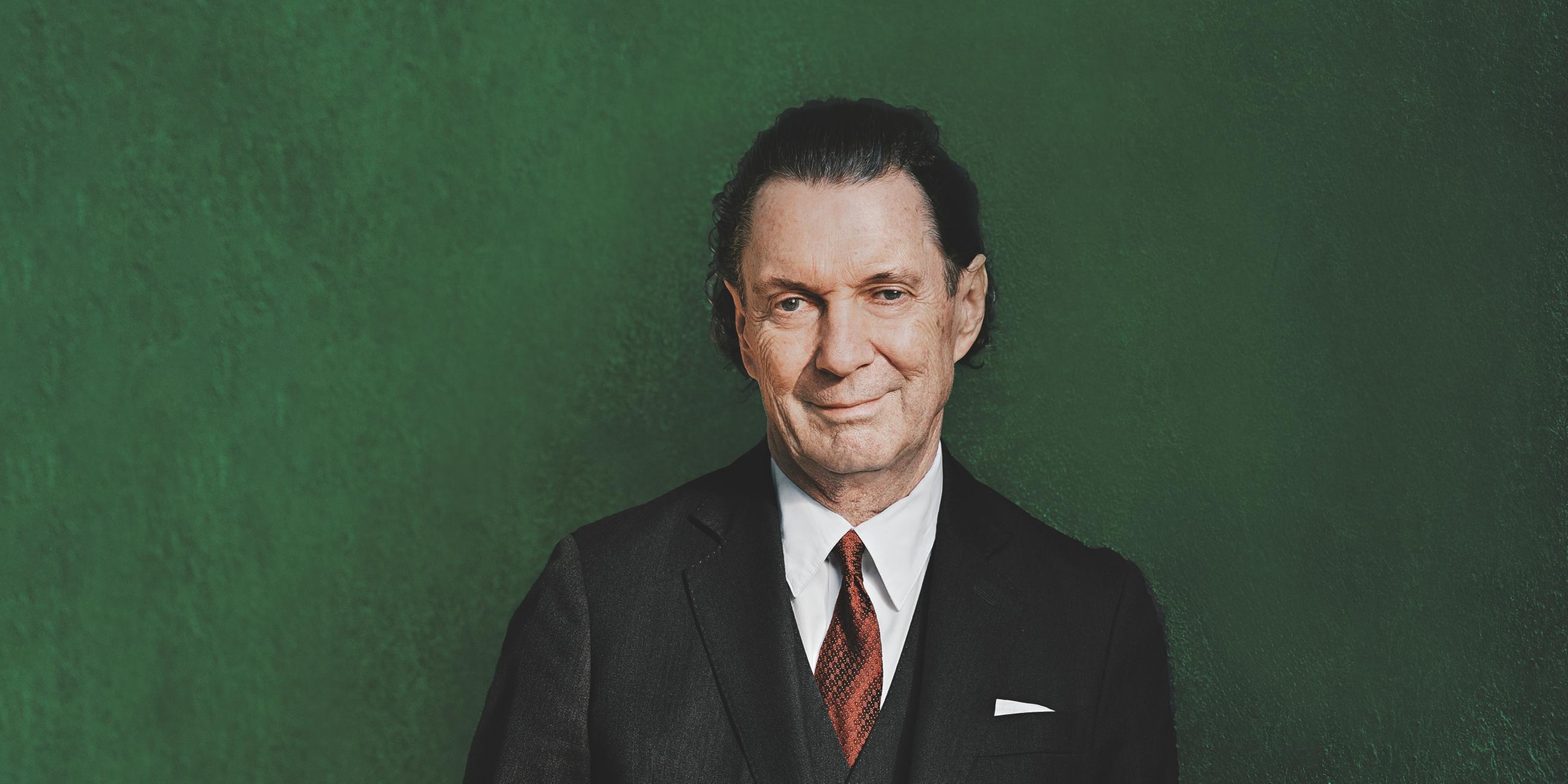 Autor Martin Suter vor grünem Hintergrund