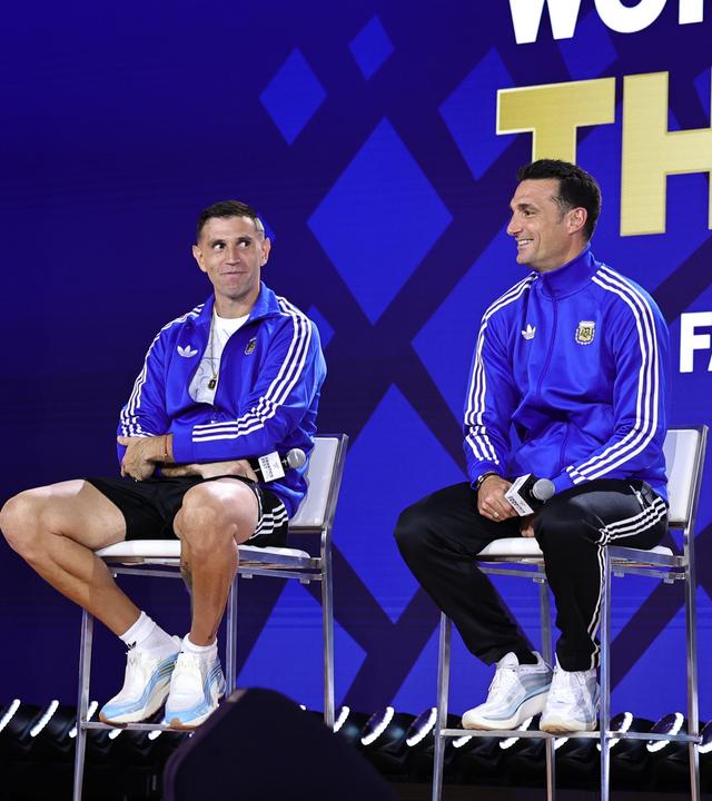 Der argentinische Nationaltrainer Lionel Scaloni sitzt mit den beiden argentinischen Nationalspielern Emiliano Martinez und Lionel Messi bei der letzten Pressekonferenz vor dem Finale