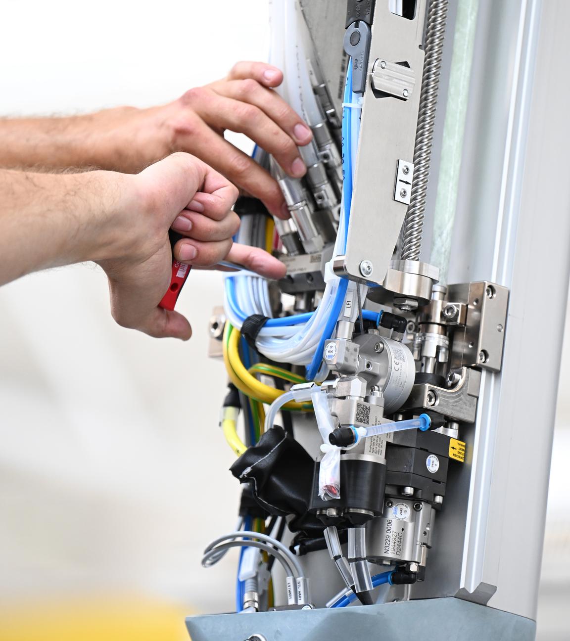 Ein Arbeiter des Maschinenbauers Dürr montiert am Stammsitz einen Roboterarm für eine Lackieranlage für Fahrzeuge.