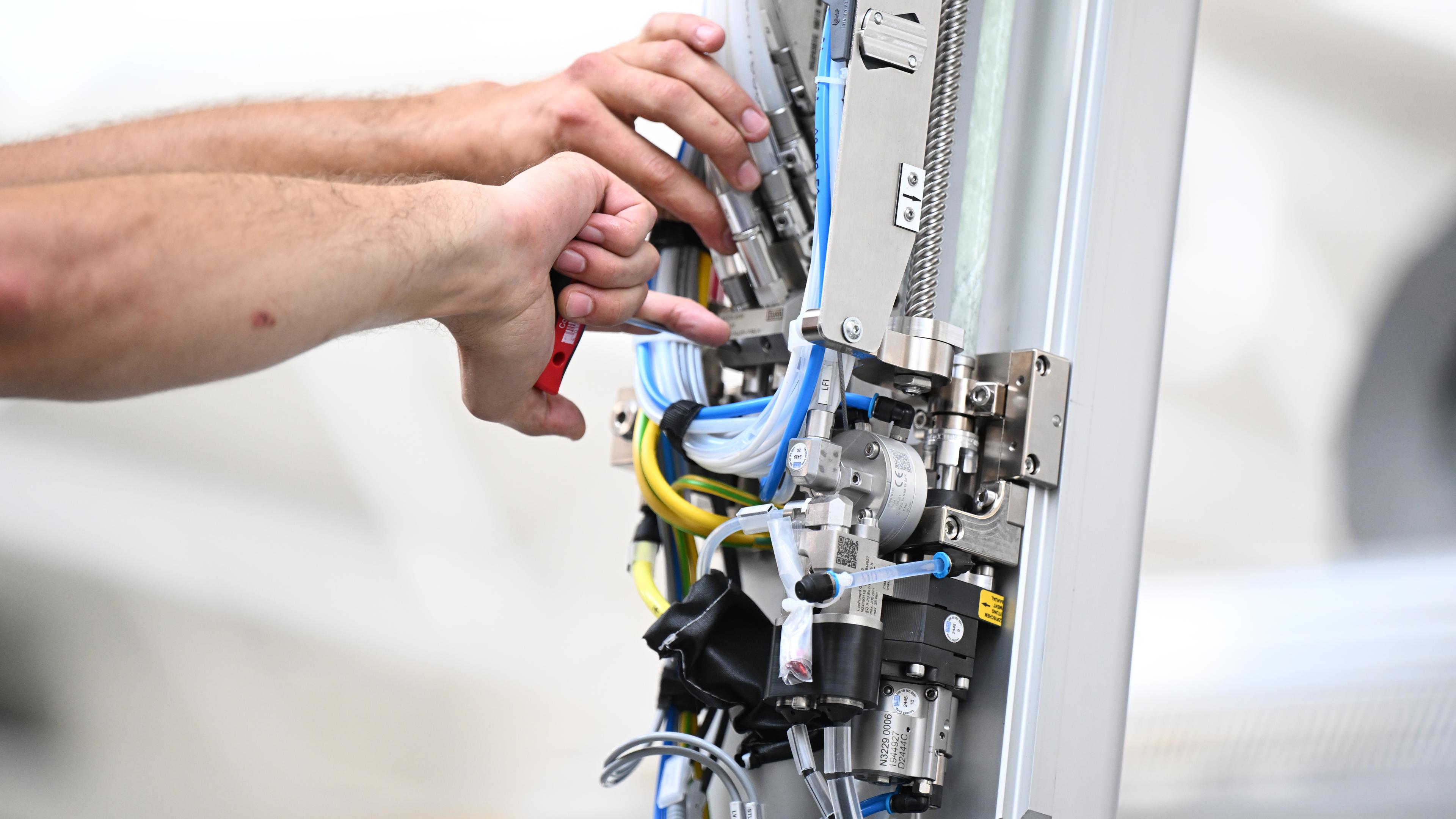 Ein Arbeiter des Maschinenbauers Dürr montiert am Stammsitz einen Roboterarm für eine Lackieranlage für Fahrzeuge.