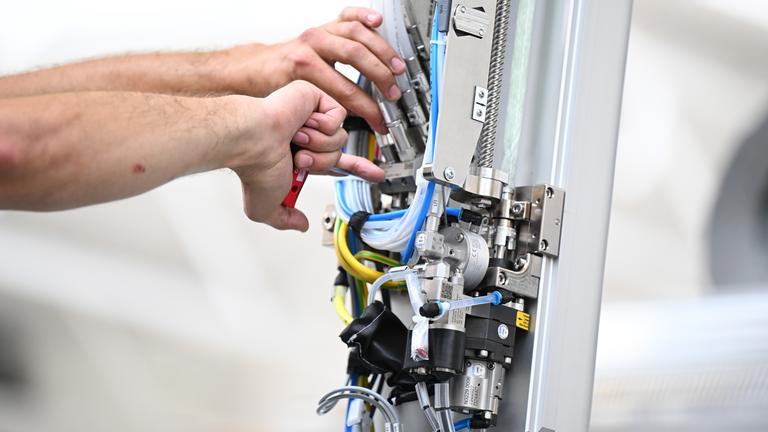 Ein Arbeiter des Maschinenbauers Dürr montiert am Stammsitz einen Roboterarm für eine Lackieranlage für Fahrzeuge.