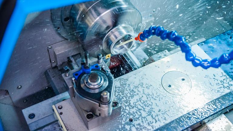 Detail einer Metallbearbeitungsmaschine, bei der Kühlwasser im Werkzeugbau zum Einsatz kommt.
