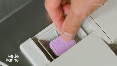 Person legt Tab in Spülmaschine