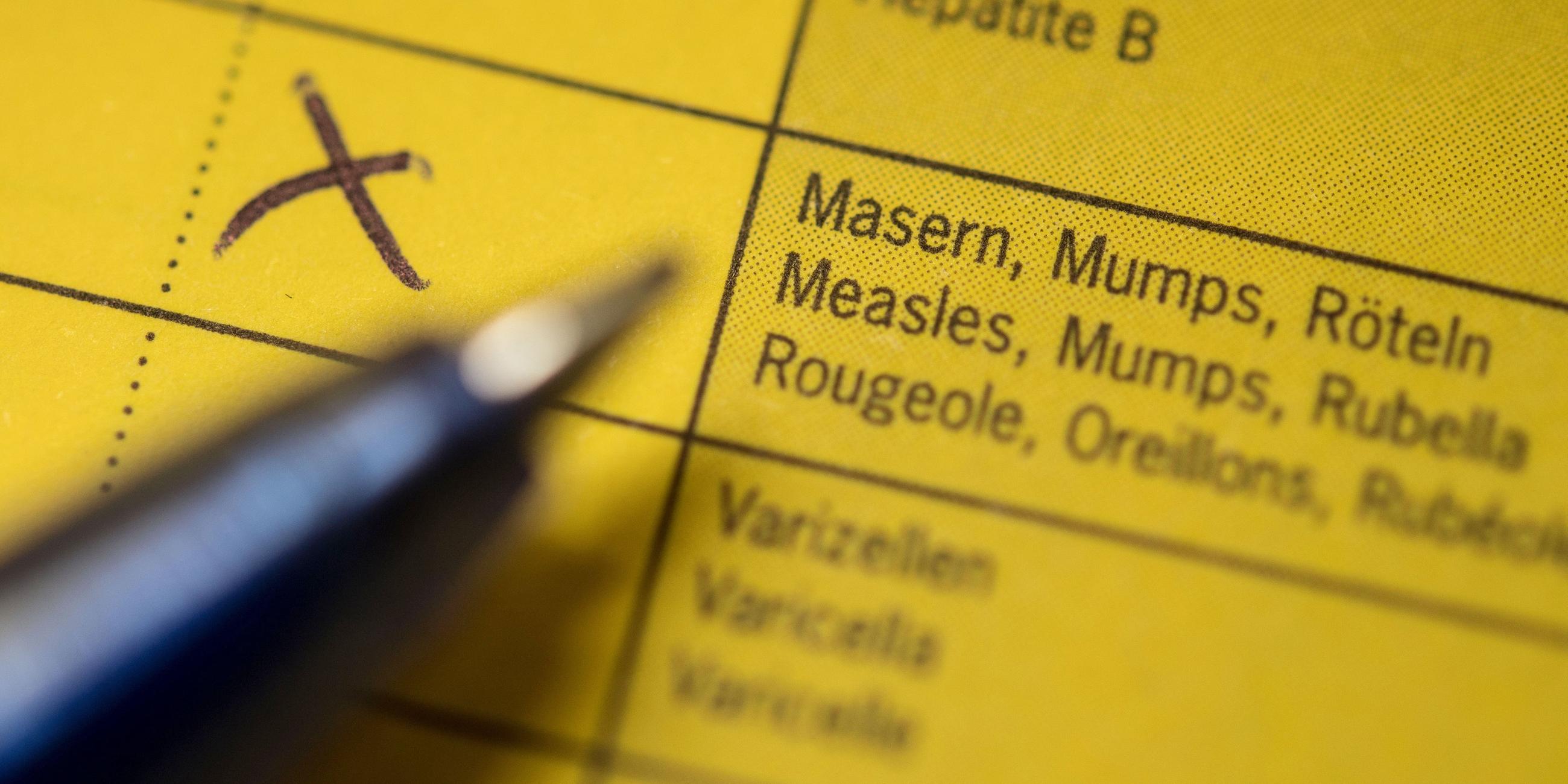 Nordrhein-Westfalen, Bielefeld: Eine Spritze liegt auf einem Impfpass in Vorbereitung auf eine Schutzimpfung gegen Masern.
