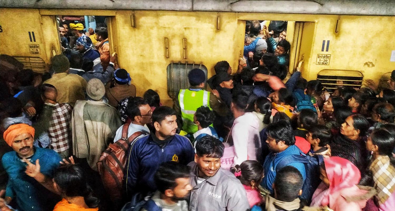 Fahrgäste drängeln sich beim Einsteigen in einen Zug am Bahnhof von Neu-Delhi.