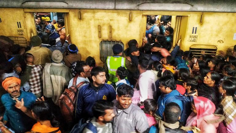 Fahrgäste drängeln sich beim Einsteigen in einen Zug am Bahnhof von Neu-Delhi.