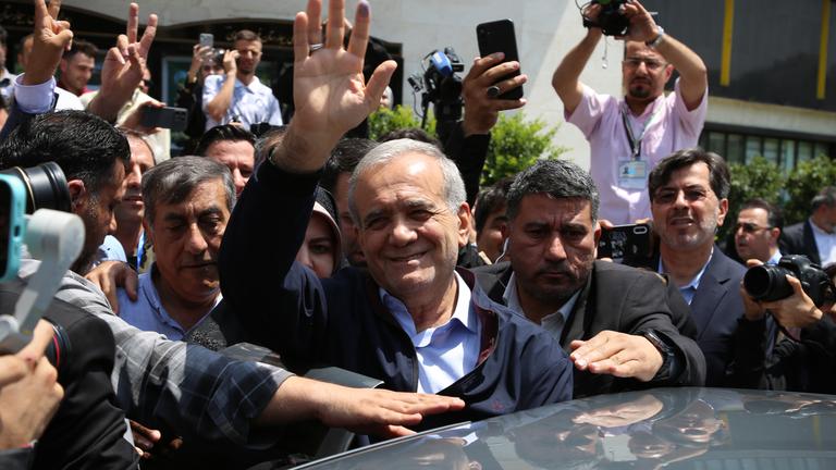 Massud Peseschkian, umgeben von Menschen, winkt in die Kamera.