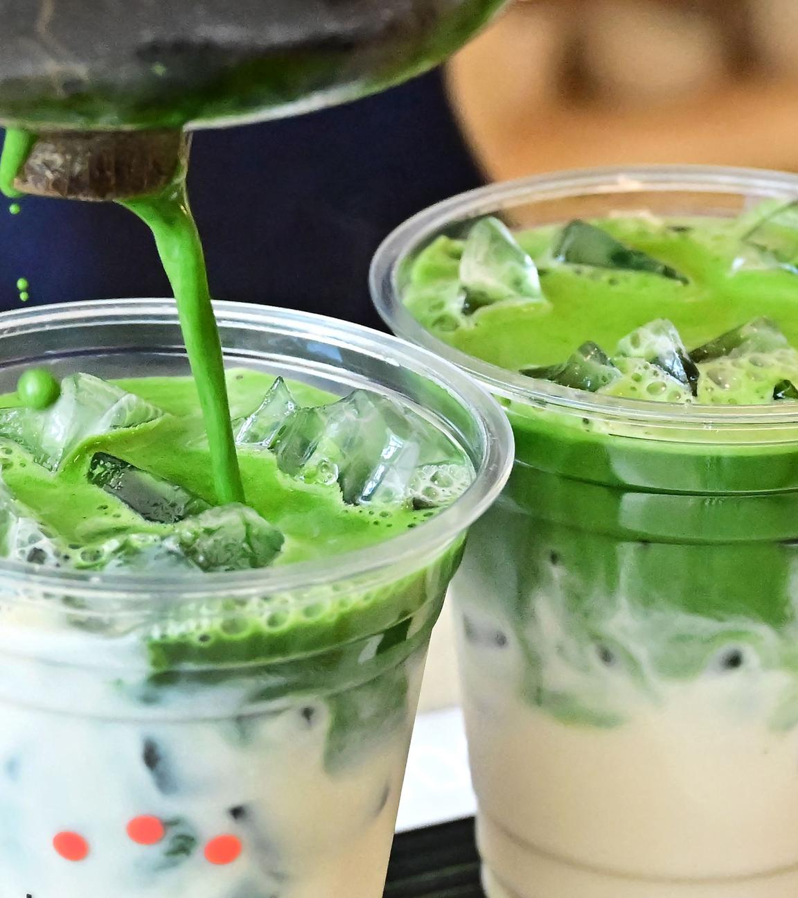 Zwei Becher Iced Matcha Latte werden zubereitet.