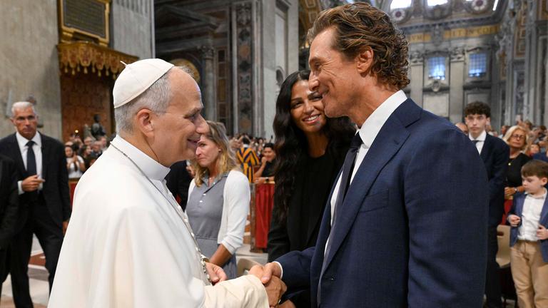 Matthew McConaughey und der Papst schütteln sich die Hände.