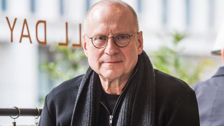 Porträtfoto eines Mannes mit Glatze und runder Brille.