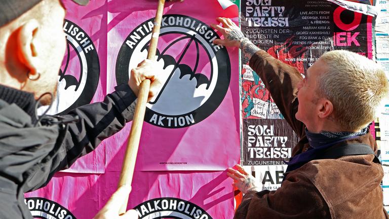 Maurice Rieger kleistert ein Plakat