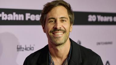 Max Giesinger posiert auf einem Event. 