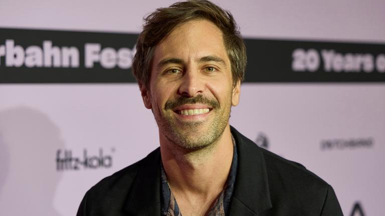 Max Giesinger posiert auf einem Event. 